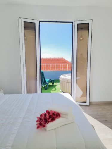 a white bed with a flower on top of it at Casa Caromba, Sunrise in Prazeres
