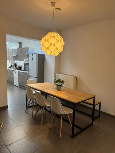 a dining room table with chairs and a yellow light at gezellige woning met tuin centrum Leuven in Leuven