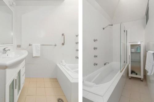 ein weißes Badezimmer mit Badewanne und Waschbecken in der Unterkunft Hyams Beach Haven, Hyams Beach in Hyams Beach
