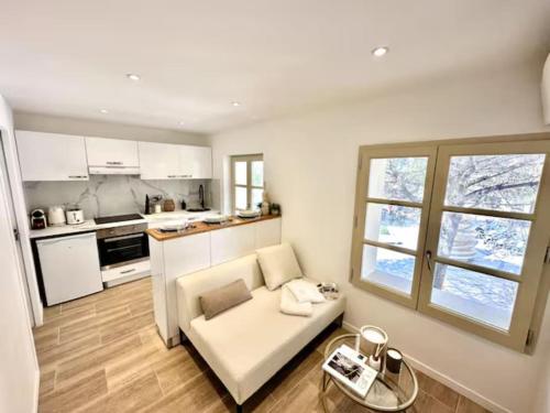 un salon avec un canapé blanc et une cuisine dans l'établissement Saint Tropez High Standing 1, à Saint-Tropez