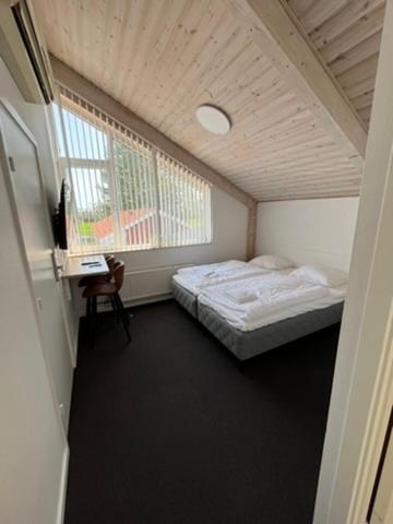 a small room with a bed and a window at Go-Sleep Bredehus in Bredsten