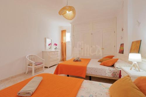 a white bedroom with two beds and a table at Villa Bio Finca With Pool in Playa Paraiso