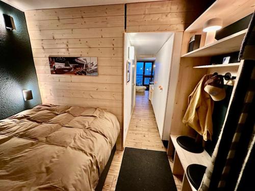 une chambre avec un lit et une porte donnant sur un couloir dans l'établissement Magnifique Studio Arcs 2000, à Bourg-Saint-Maurice
