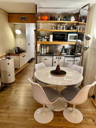 une cuisine avec une table et des chaises dans une pièce dans l'établissement Magnifique Studio Arcs 2000, à Bourg-Saint-Maurice