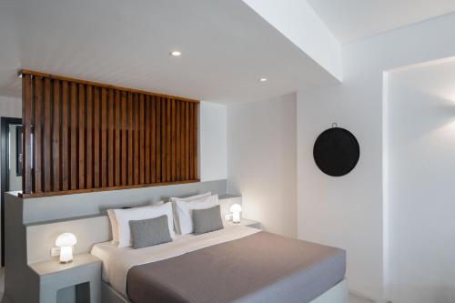 a bedroom with a bed with two lights on it at Santorini Princess Spa Hotel in Imerovigli