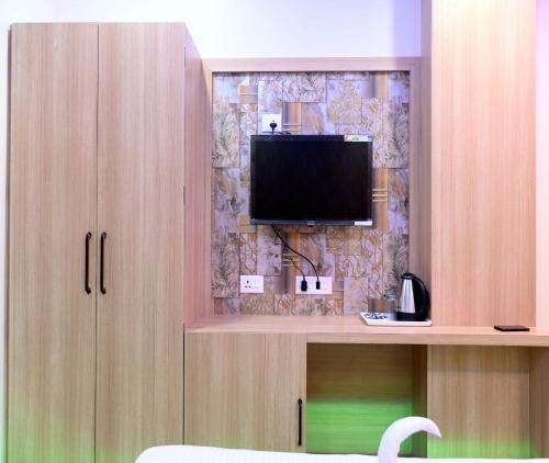 a room with a television on a wall at Hotel Shankara Residency in Varanasi