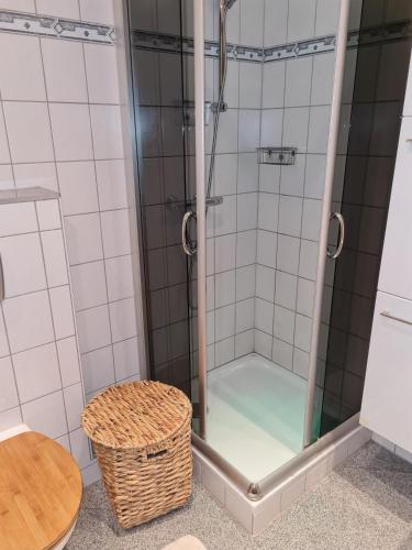 a shower in a bathroom with a wicker stool at Haus Poldi in Trassem