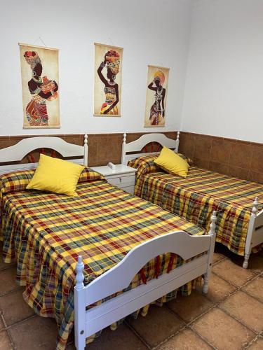two beds sitting next to each other in a room at Casa Adelfa in Algodonales