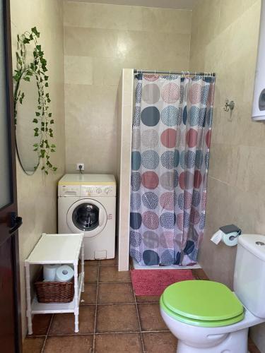 a bathroom with a toilet and a washing machine at Casa Adelfa in Algodonales
