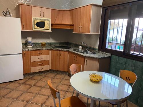 a kitchen with a table and a sink and a refrigerator at Casa Adelfa in Algodonales