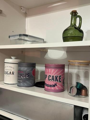 a shelf with jars and a bottle on it at Apartamenty Warszawska in Toruń