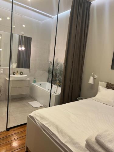 a bedroom with a bed and a tub and a sink at Apartamenty Warszawska in Toruń