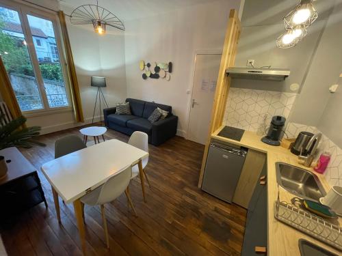 une cuisine et un salon avec une table et un canapé dans l'établissement Saphir 1, à Vichy
