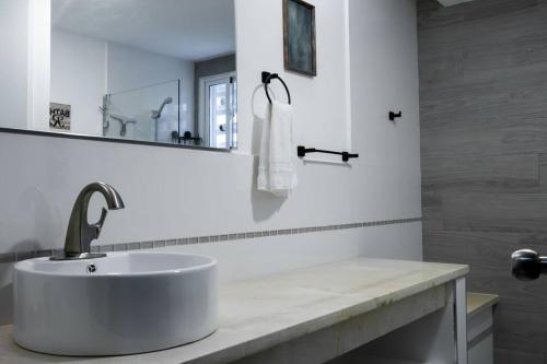 a white bathroom with a sink and a mirror at Modern and quiet condo in La Romana DR in La Romana