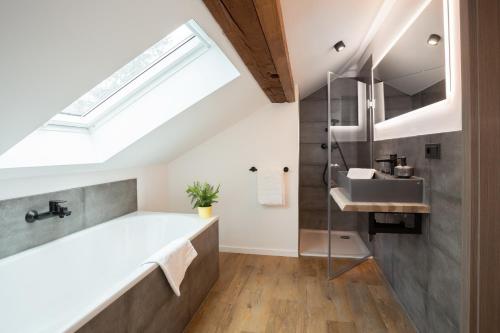 a bathroom with a large bath tub and a skylight at Lieblingsquartier komplett in Sankt Andreasberg