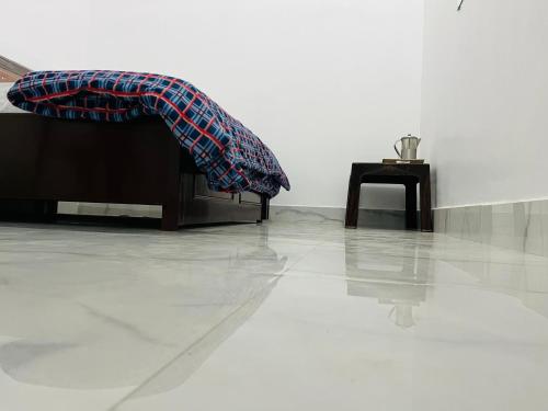 a person laying on a couch with their legs on a table at Mangalayatan Home Stay Ayodhya in Faizābād
