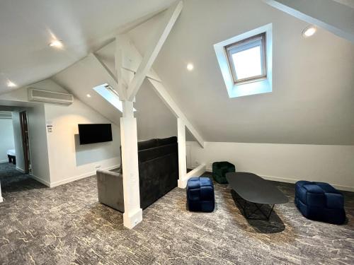 a living room with a couch and a table and a tv at Hotel Balmoral Dinard in Dinard