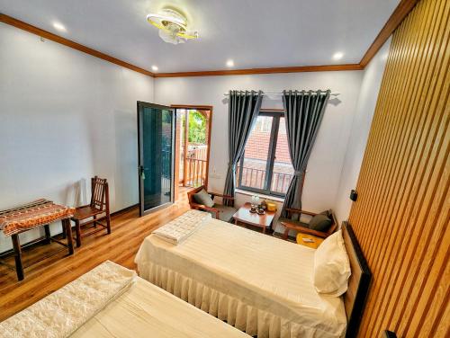 Una habitación de hotel con dos camas y balcón. en Ninh Binh Greenland Homestay, en Ninh Binh