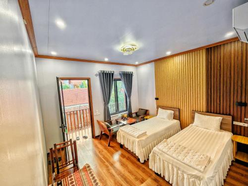 Una habitación de hotel con dos camas y una ventana. en Ninh Binh Greenland Homestay, en Ninh Binh