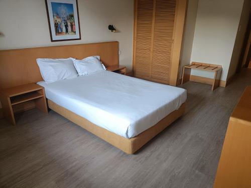 a bedroom with a large bed with white sheets at Flag Hotel Porto Maia in Águas Santas