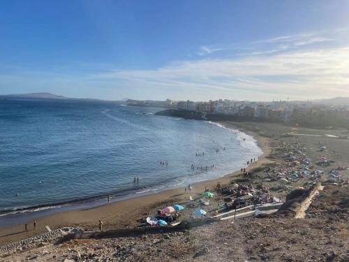 ein Strand mit vielen Menschen und das Meer in der Unterkunft Luxury Villa in Melenara in Las Palmas de Gran Canaria