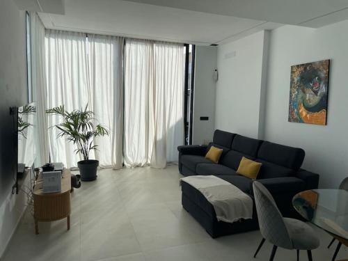 ein Wohnzimmer mit einem blauen Sofa und einem Tisch in der Unterkunft Luxury Villa in Melenara in Las Palmas de Gran Canaria