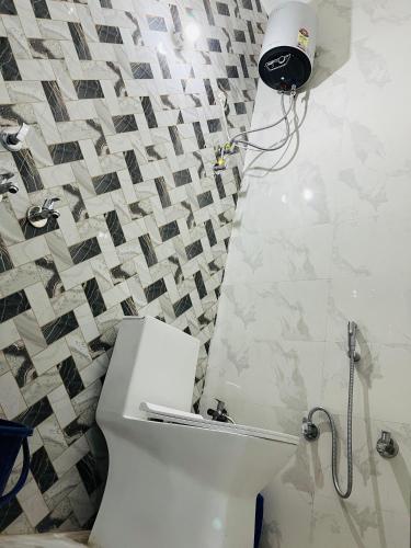 a bathroom with a toilet and a shower in it at Mangalayatan Home Stay Ayodhya in Faizābād