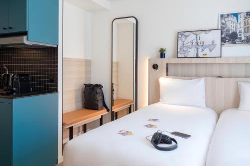 a hotel room with a bed and a kitchen at Aparthotel Adagio Access Rouen Centre Cathédrale in Rouen