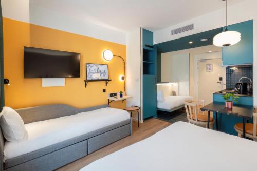 a hotel room with a bed and a living room at Aparthotel Adagio Access Rouen Centre Cathédrale in Rouen