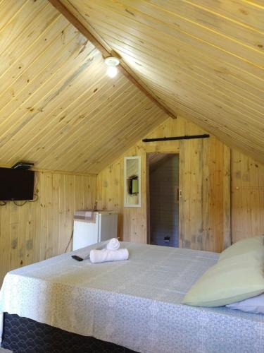 a bedroom with a large bed in a wooden ceiling at Chalés Baruch in Sapucaí-Mirim