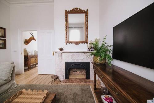 a living room with a fireplace and a mirror at Merchant on Malop - Luxe City Escape in Geelong