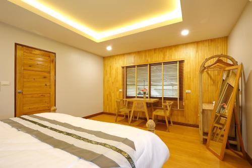 a bedroom with a bed and a table and a ladder at Mata villa มาตา วิลล่า in Chiang Mai