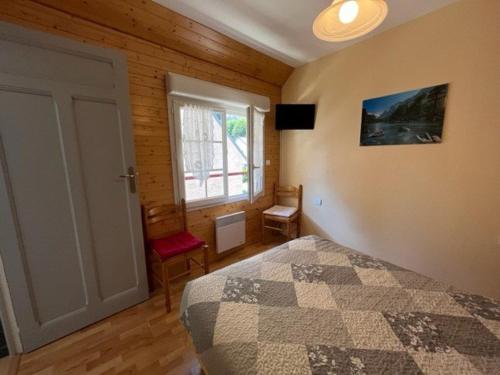 une chambre avec un lit et une grande fenêtre dans l'établissement Confortable appart 2 chambres, terrasse, près télécabines à Cauterets - FR-1-812-106, à Cauterets