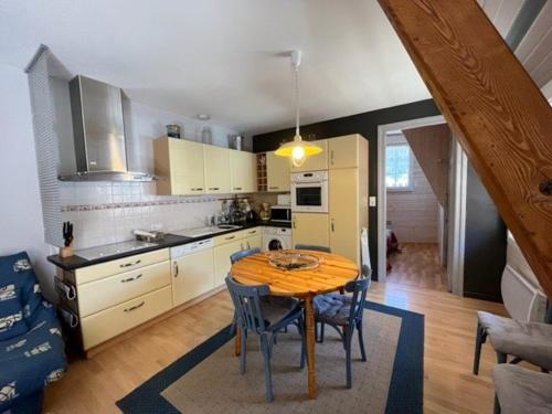 une cuisine avec une table et des chaises dans une pièce dans l'établissement Confortable appart 2 chambres, terrasse, près télécabines à Cauterets - FR-1-812-106, à Cauterets