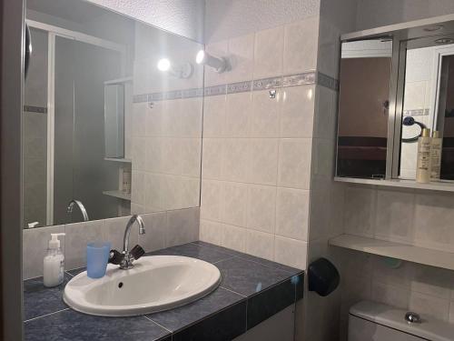 une salle de bain avec un lavabo et un miroir dans l'établissement Studio central 4 pers, proche télécabines, cellier à skis - FR-1-812-16, à Cauterets