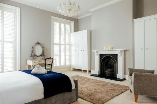 a bedroom with a bed and a fireplace at Character Cheltenham Georgian Town House in Gloucestershire