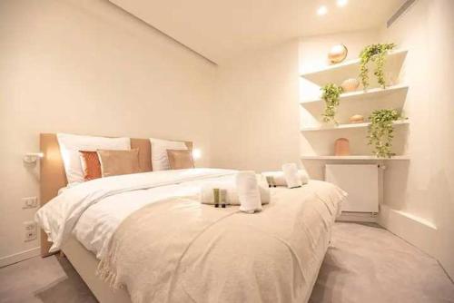 une chambre avec un grand lit avec deux serviettes dessus dans l'établissement Superb Appt with AC - 2BD-6P - Madeleine-Opera, à Paris