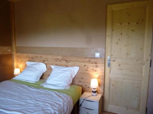 - un lit avec 2 oreillers blancs et 2 lampes dans l'établissement Gîte de 100m2 dans maison passive en paille, à Saint-Michel-de-Chaillol