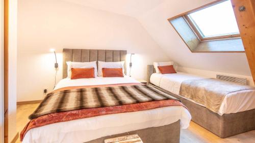 - une chambre mansardée avec 2 lits et une fenêtre dans l'établissement Fermes de ST Sorlin - LE FREZZIA N 204 - 3P8, à Saint-Sorlin-dʼArves