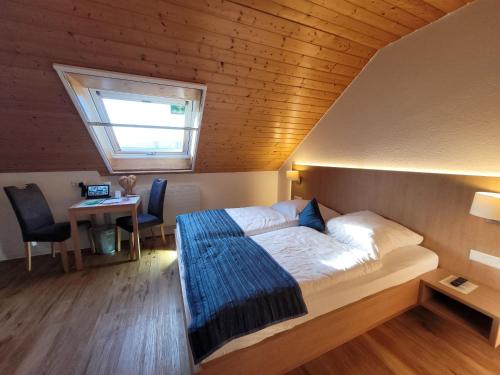 a bedroom with a bed and a window and a desk at Stahlecker Hof in Lichtenstein