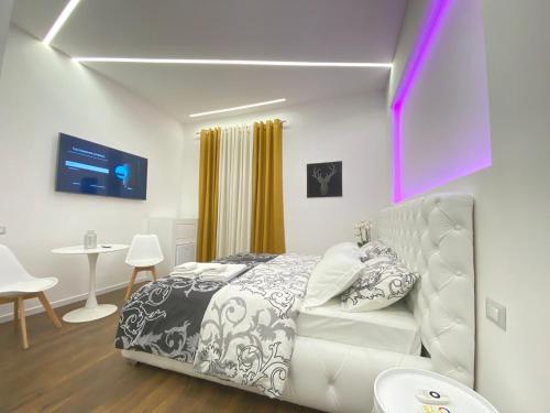 um quarto com uma cama branca, uma mesa e cadeiras em Vatican G&G Suites em Roma