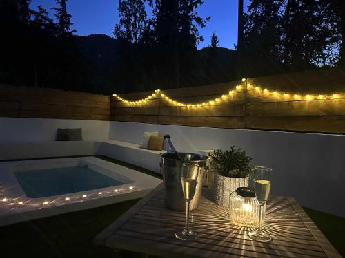 a hot tub with two wine glasses and lights at Suite lima - benamahoma in Benamahoma