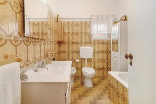 ein Badezimmer mit Toilette, Waschbecken und Badewanne in der Unterkunft Elegant Vintage House with barbecue in Cascais