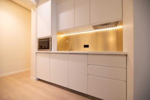 une cuisine avec des armoires blanches et un évier dans l'établissement Elegant Apt with AC - 2BR-6P -Palais Garnier, à Paris