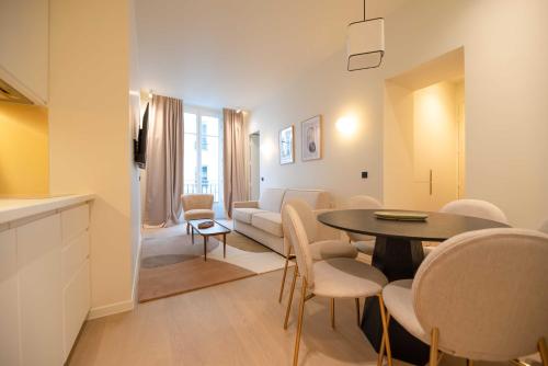 un salon avec une table, des chaises et un canapé dans l'établissement Elegant Apt with AC - 2BR-6P -Palais Garnier, à Paris