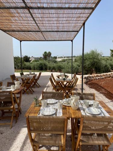 a wooden table with chairs and plates on it at Masseria Ramasian in Monopoli