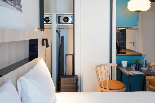 a bedroom with a bed and a desk and a kitchen at Aparthotel Adagio Access Rouen Centre Cathédrale in Rouen