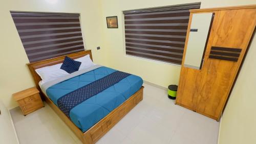 a bedroom with a bed and a window at Golden pearl private villa with pool in Vythiri