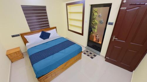 a small bedroom with a bed and a door at Golden pearl private villa with pool in Vythiri