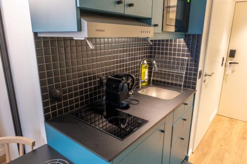 a small kitchen with a sink and a counter top at Aparthotel Adagio Access Rouen Centre Cathédrale in Rouen